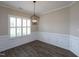 Elegant dining room with hardwood floors, wainscoting, and a modern chandelier at 63 Whistling Duck Way, Wendell, NC 27591