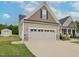 Attached two car garage with a spacious driveway and shed, featuring durable construction at 63 Whistling Duck Way, Wendell, NC 27591
