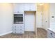 Kitchen details: sleek built-in oven, matching cabinets and drawers, and designated refrigerator space on wood-look floors at 63 Whistling Duck Way, Wendell, NC 27591