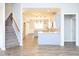 Open floor plan showcasing the staircase and a modern kitchen with an island and modern pendant lights at 63 Whistling Duck Way, Wendell, NC 27591