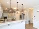 An open kitchen showcases the elegant pendant lighting, countertop seating, and stainless steel appliances at 63 Whistling Duck Way, Wendell, NC 27591