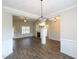 Open-concept living room with hardwood flooring, fireplace, and elegant chandelier at 63 Whistling Duck Way, Wendell, NC 27591