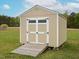 Storage shed with neutral siding, double doors, and a ramp on a sunny day at 63 Whistling Duck Way, Wendell, NC 27591