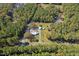 Expansive aerial view of a secluded property with a house, outbuildings, and surrounded by lush greenery and trees at 6418 Beaver Creek Rd, New Hill, NC 27562