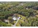 Aerial view showcasing a charming property nestled among lush trees and featuring a house, outbuildings, and long driveway at 6418 Beaver Creek Rd, New Hill, NC 27562