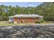 Back view of home featuring gravel parking and mature, lush landscaping at 6418 Beaver Creek Rd, New Hill, NC 27562