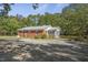 Back view of home with large gravel parking area and mature trees at 6418 Beaver Creek Rd, New Hill, NC 27562