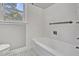 Bright bathroom featuring a tiled shower-tub combination, toilet, and black and white checkered flooring at 6418 Beaver Creek Rd, New Hill, NC 27562