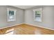 Light-filled bedroom featuring hardwood flooring, baseboard trim, recessed lighting, and two windows with natural light at 6418 Beaver Creek Rd, New Hill, NC 27562