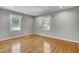 Bright bedroom with hardwood floors, neutral walls, recessed lighting, and two windows allowing natural light at 6418 Beaver Creek Rd, New Hill, NC 27562