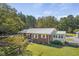 Charming brick home with a metal roof and lush green lawn and mature trees at 6418 Beaver Creek Rd, New Hill, NC 27562