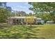 Brick ranch home with mature landscaping, metal roof, and covered front porch at 6418 Beaver Creek Rd, New Hill, NC 27562
