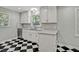 Well-lit kitchen featuring gray countertops, white cabinets, and checkerboard floors at 6418 Beaver Creek Rd, New Hill, NC 27562