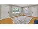 Bright living room with hardwood floors, a decorative rug, and a large window with natural light at 6418 Beaver Creek Rd, New Hill, NC 27562