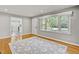 Light filled living room with hardwood floors and large windows overlooking backyard at 6418 Beaver Creek Rd, New Hill, NC 27562