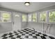 Cozy mud room featuring a black and white checkered floor, bright walls, and multiple windows bringing in natural light at 6418 Beaver Creek Rd, New Hill, NC 27562