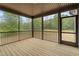 Relaxing screened-in back porch with natural wood flooring and picturesque view of the wooded backyard at 65 Leisure Ln # 6, Louisburg, NC 27549