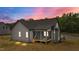 Exterior of gray home with a screened-in back porch as twilight accentuates the outdoor space at 65 Leisure Ln # 6, Louisburg, NC 27549