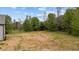 Expansive, flat backyard featuring verdant trees and a partial view of the home's exterior at 65 Leisure Ln # 6, Louisburg, NC 27549