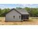 Back of home with a screened-in porch and gray siding that offers a peek into the natural outdoor setting at 65 Leisure Ln # 6, Louisburg, NC 27549