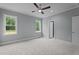 Bright bedroom features plush carpeting, two windows letting in ample natural light, and a modern ceiling fan at 65 Leisure Ln # 6, Louisburg, NC 27549