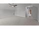 Large empty room with neutral colored carpet and walls; a ceiling fan provides comfort at 65 Leisure Ln # 6, Louisburg, NC 27549