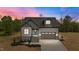 Charming new construction home featuring stone accents, a two-car garage, and a welcoming teal front door at 65 Leisure Ln # 6, Louisburg, NC 27549