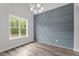 Bright room featuring an accent wall, a modern chandelier, and a large window that provides ample natural light at 65 Leisure Ln # 6, Louisburg, NC 27549