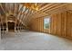 Large unfinished bonus room with exposed wood framing, and a window overlooking a green space at 65 Leisure Ln # 6, Louisburg, NC 27549