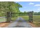 Gated entrance to a beautiful property with mature trees and a long gravel driveway leading to the home at 6600 Maynard Farm Rd, Chapel Hill, NC 27516