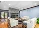 Cozy living room featuring a stone fireplace, hardwood floors, and comfortable seating arrangement, perfect for relaxation at 6600 Maynard Farm Rd, Chapel Hill, NC 27516