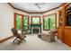 Cozy seating area with fireplace in the main bedroom with view of outdoor greenery at 6600 Maynard Farm Rd, Chapel Hill, NC 27516