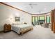 Spacious main bedroom with a fireplace, ceiling fan, and multiple windows at 6600 Maynard Farm Rd, Chapel Hill, NC 27516