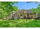 Expansive backyard with a lush lawn, mature trees, a deck, and a firepit, perfect for outdoor living at 6600(A) Maynard Farm Rd, Chapel Hill, NC 27516