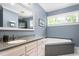Well-lit bathroom featuring granite counters and a large soaking tub by a window at 6600(A) Maynard Farm Rd, Chapel Hill, NC 27516