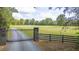 Estate home with a stone pillar gated entrance and long tree lined driveway leading to the residence at 6600(A) Maynard Farm Rd, Chapel Hill, NC 27516