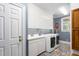 Bright laundry room featuring white cabinets, a sink, and modern washer and dryer units for convenience at 6600(A) Maynard Farm Rd, Chapel Hill, NC 27516