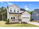 Lovely two-story home with a gray roof, two-car garage, and a quaint front porch area at 67 Comfort Ct, Fuquay Varina, NC 27526