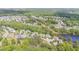 Aerial view of a neighborhood surrounded by mature trees and foliage next to a body of water at 6925 Rex Rd, Holly Springs, NC 27540
