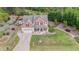 Aerial view of a two-story home with a two-car garage, a covered porch, and a large, well-manicured lawn at 6925 Rex Rd, Holly Springs, NC 27540