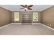 Spacious bedroom with neutral walls and carpet, a ceiling fan, and natural light from two windows at 6925 Rex Rd, Holly Springs, NC 27540