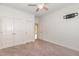 Bedroom with neutral carpet and walls, ceiling fan, and closet at 6925 Rex Rd, Holly Springs, NC 27540