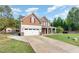 Two-story home with a two-car garage, red shutters, a covered porch, and a well-manicured lawn at 6925 Rex Rd, Holly Springs, NC 27540