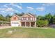 Charming two-story home with a covered porch, a well-maintained lawn, and professional landscaping at 6925 Rex Rd, Holly Springs, NC 27540