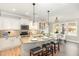Well-lit kitchen with granite countertops, stainless steel appliances, island with barstools, and dining area at 6925 Rex Rd, Holly Springs, NC 27540