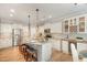 Bright kitchen boasts an island with seating, stainless appliances, and stylish pendant lighting at 6925 Rex Rd, Holly Springs, NC 27540