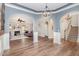 Open-concept living area with hardwood floors, elegant archways, and neutral paint at 6925 Rex Rd, Holly Springs, NC 27540