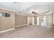 Large main bedroom with carpet and access to other rooms at 6925 Rex Rd, Holly Springs, NC 27540