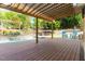 Covered deck showcasing the pool with landscaping and outdoor seating, creating a backyard oasis at 6925 Rex Rd, Holly Springs, NC 27540
