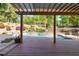 Backyard view from covered deck with a pool and luxurious landscaping with flowers and manicured shrubbery at 6925 Rex Rd, Holly Springs, NC 27540